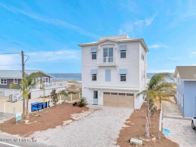 coastal home featuring a garage, driveway, and a balcony