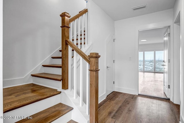 stairs featuring baseboards, visible vents, and wood finished floors