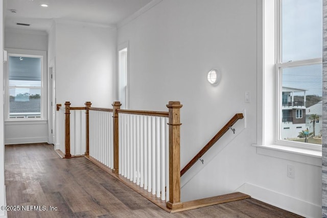 hall featuring plenty of natural light, wood finished floors, crown molding, and an upstairs landing