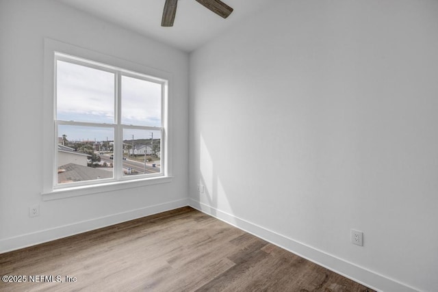 spare room with a ceiling fan, baseboards, and wood finished floors