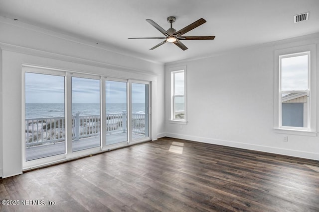 empty room with dark wood-type flooring, visible vents, baseboards, and a ceiling fan