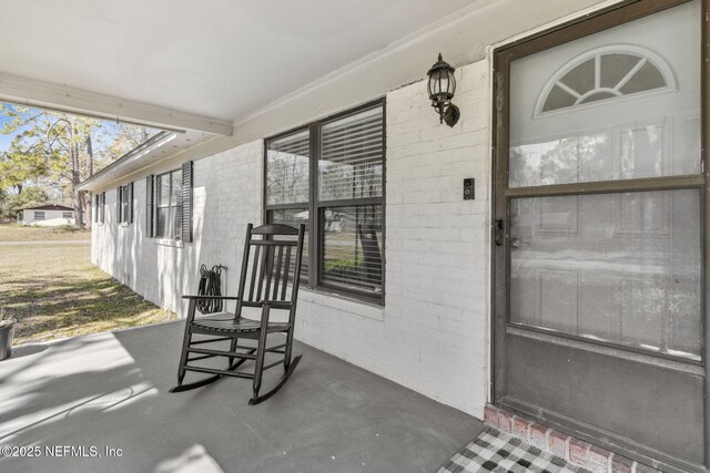 view of exterior entry with brick siding