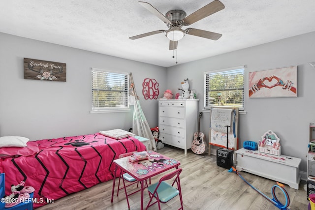 bedroom featuring a textured ceiling, a ceiling fan, and wood finished floors