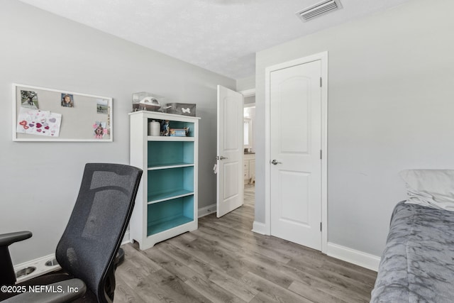 office with visible vents, baseboards, and wood finished floors