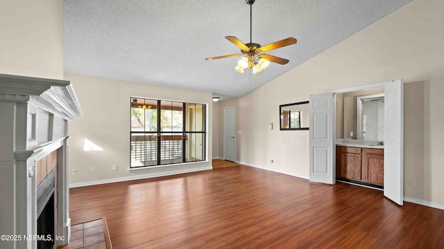 unfurnished living room with dark wood finished floors, a fireplace with flush hearth, a ceiling fan, a textured ceiling, and baseboards