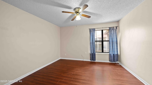 empty room with ceiling fan, a textured ceiling, wood finished floors, and baseboards