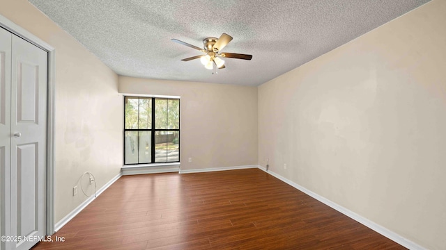 empty room with ceiling fan, a textured ceiling, baseboards, and wood finished floors