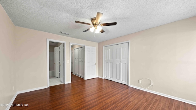 unfurnished bedroom featuring baseboards, visible vents, ceiling fan, wood finished floors, and a textured ceiling