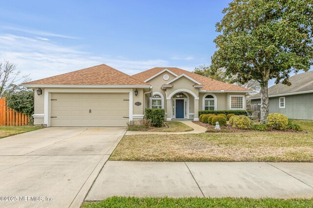 view of front of house featuring a garage, concrete driveway, fence, and stucco siding