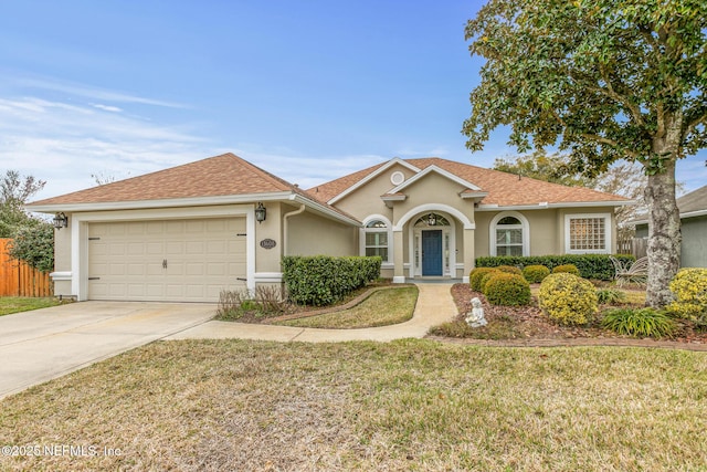 view of front of house featuring a garage, concrete driveway, stucco siding, roof with shingles, and a front yard