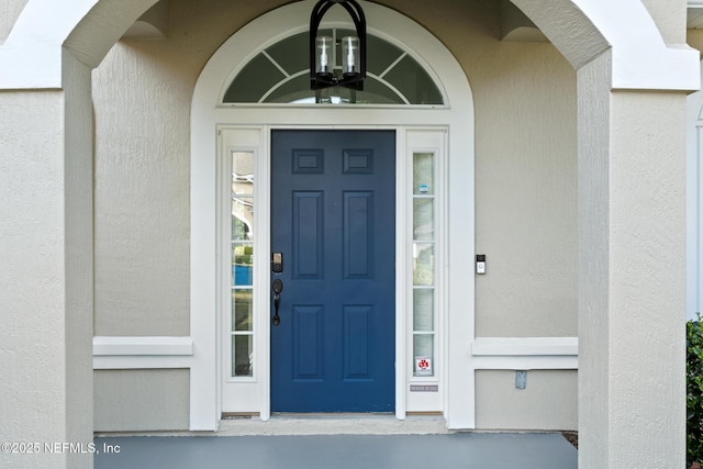 doorway to property featuring stucco siding