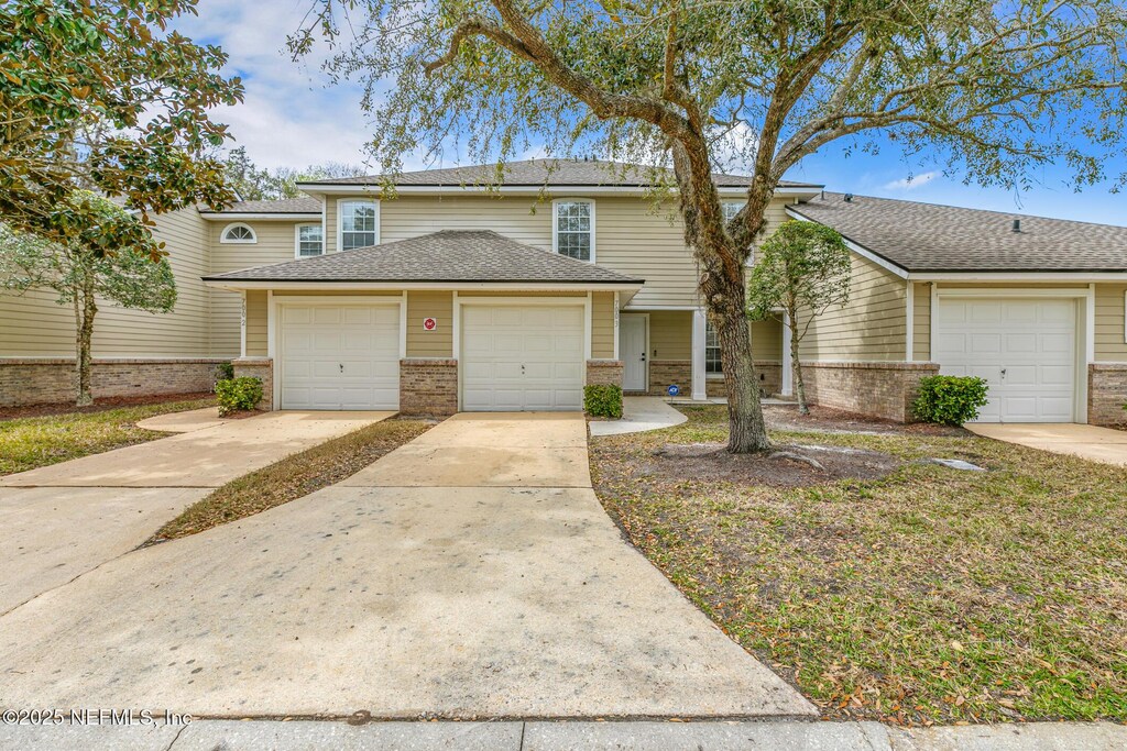 700 S Covered Bridge Rd Unit 3, Saint Johns, FL 32259 - view of front of property with a garage, a shingled roof, and brick siding