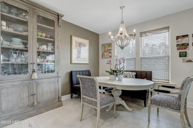 11334 Newtonian Blvd, Jacksonville, FL 32256 - dining area with baseboards, breakfast area, light tile patterned flooring, and a notable chandelier