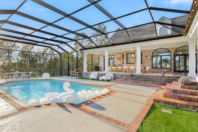 outdoor pool with glass enclosure and a patio area