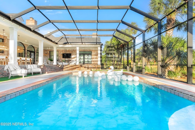 outdoor pool with a lanai and a patio area