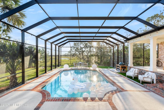 pool featuring glass enclosure and a patio