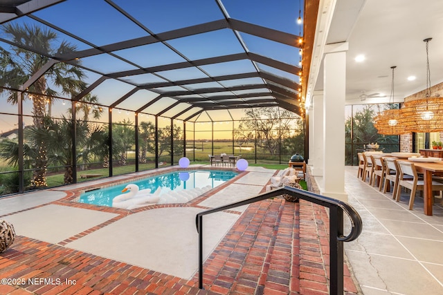 outdoor pool with outdoor dining space, glass enclosure, a patio area, and ceiling fan