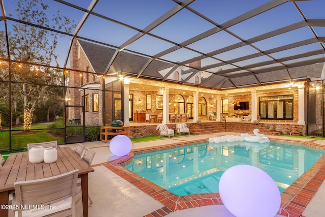 outdoor pool featuring glass enclosure, a patio area, and a fireplace