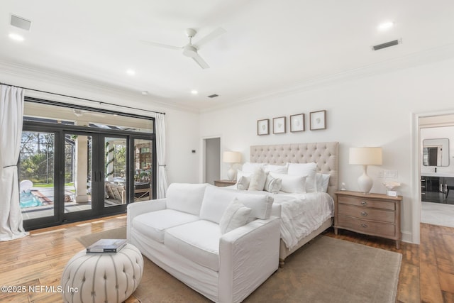 bedroom with crown molding, wood-type flooring, visible vents, and access to exterior