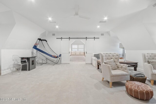 interior space with a barn door, ceiling fan, vaulted ceiling, carpet flooring, and recessed lighting