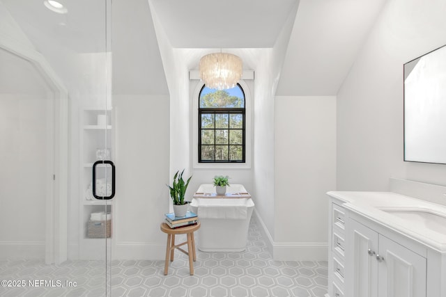 bathroom with lofted ceiling, a freestanding tub, a notable chandelier, vanity, and a shower stall