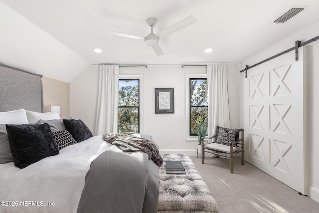 bedroom featuring carpet floors, a barn door, multiple windows, and visible vents