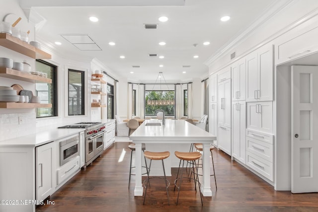 kitchen featuring appliances with stainless steel finishes, light countertops, crown molding, and open shelves