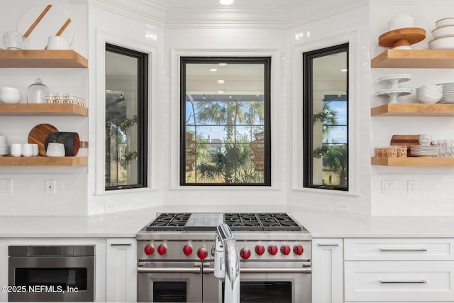 kitchen featuring open shelves, light countertops, white cabinets, and double oven range