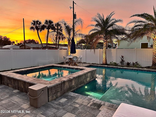 view of pool featuring a fenced in pool, an in ground hot tub, a patio, and fence