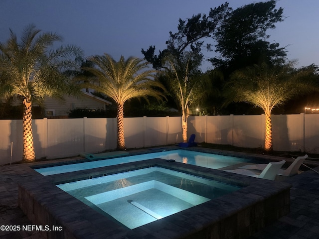 view of swimming pool with an in ground hot tub and a fenced backyard