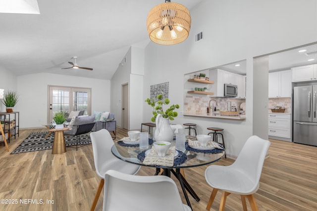 dining area with recessed lighting, visible vents, high vaulted ceiling, light wood-type flooring, and ceiling fan with notable chandelier