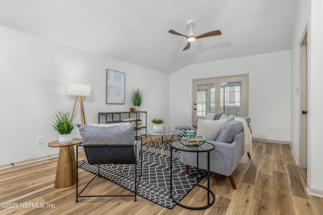 living area featuring ceiling fan, vaulted ceiling, baseboards, and wood finished floors