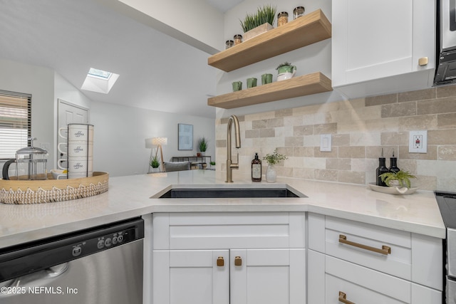 kitchen featuring dishwasher, light countertops, a sink, and white cabinetry