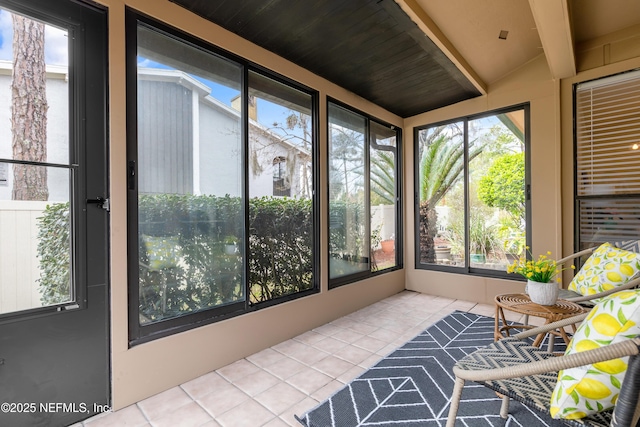 sunroom featuring beamed ceiling