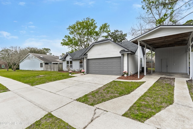 view of front of house featuring a shingled roof, concrete driveway, an attached garage, a front lawn, and a carport