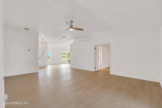 spare room with a ceiling fan, visible vents, light wood-style flooring, and a textured ceiling