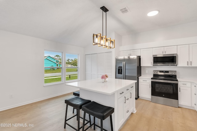 kitchen with stainless steel appliances, light countertops, light wood finished floors, and white cabinetry