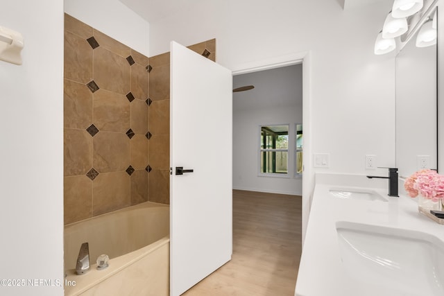 bathroom with shower / bath combination, a sink, and wood finished floors