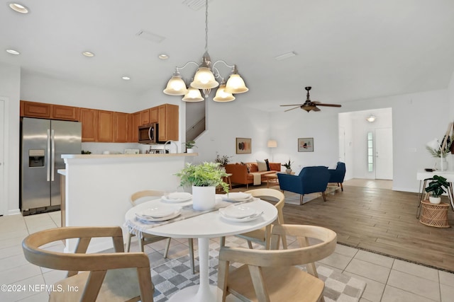 dining space featuring light tile patterned floors, ceiling fan with notable chandelier, and recessed lighting