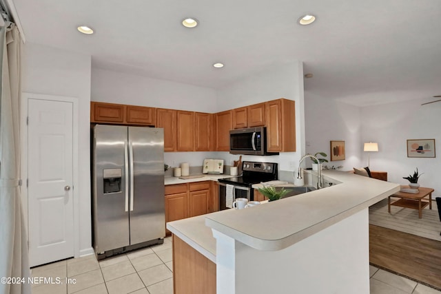 kitchen featuring light tile patterned floors, recessed lighting, a peninsula, light countertops, and appliances with stainless steel finishes