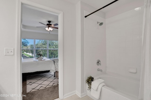 ensuite bathroom with baseboards, ceiling fan, bathing tub / shower combination, and ensuite bath