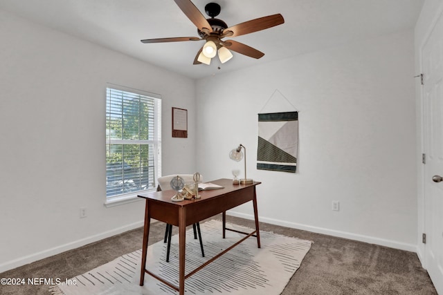 carpeted home office with ceiling fan and baseboards