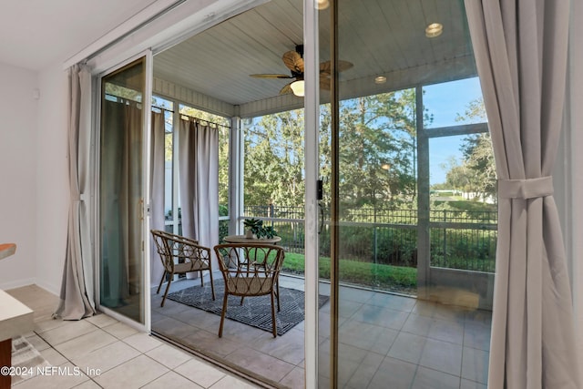 unfurnished sunroom featuring ceiling fan