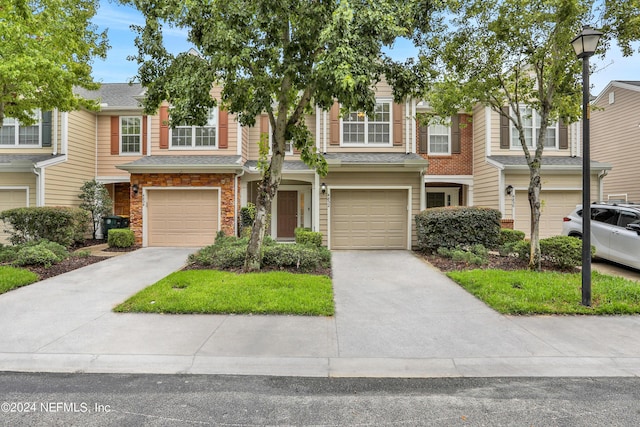 townhome / multi-family property featuring concrete driveway and an attached garage