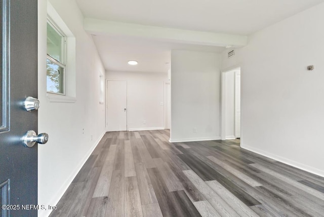 empty room featuring visible vents, baseboards, and wood finished floors