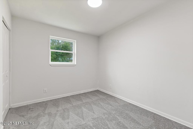 unfurnished bedroom with a closet, carpet flooring, and baseboards