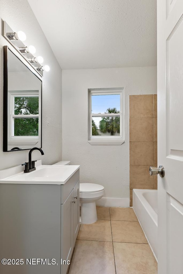 full bathroom with toilet, a bathing tub, tile patterned floors, a textured ceiling, and vanity