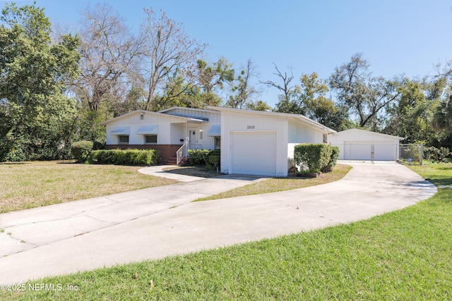 view of front facade featuring a front lawn, a detached garage, fence, and a gate