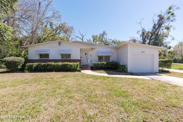 ranch-style home with a garage, driveway, a front lawn, and brick siding