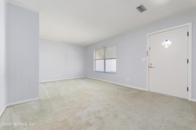 spare room with carpet, visible vents, and baseboards